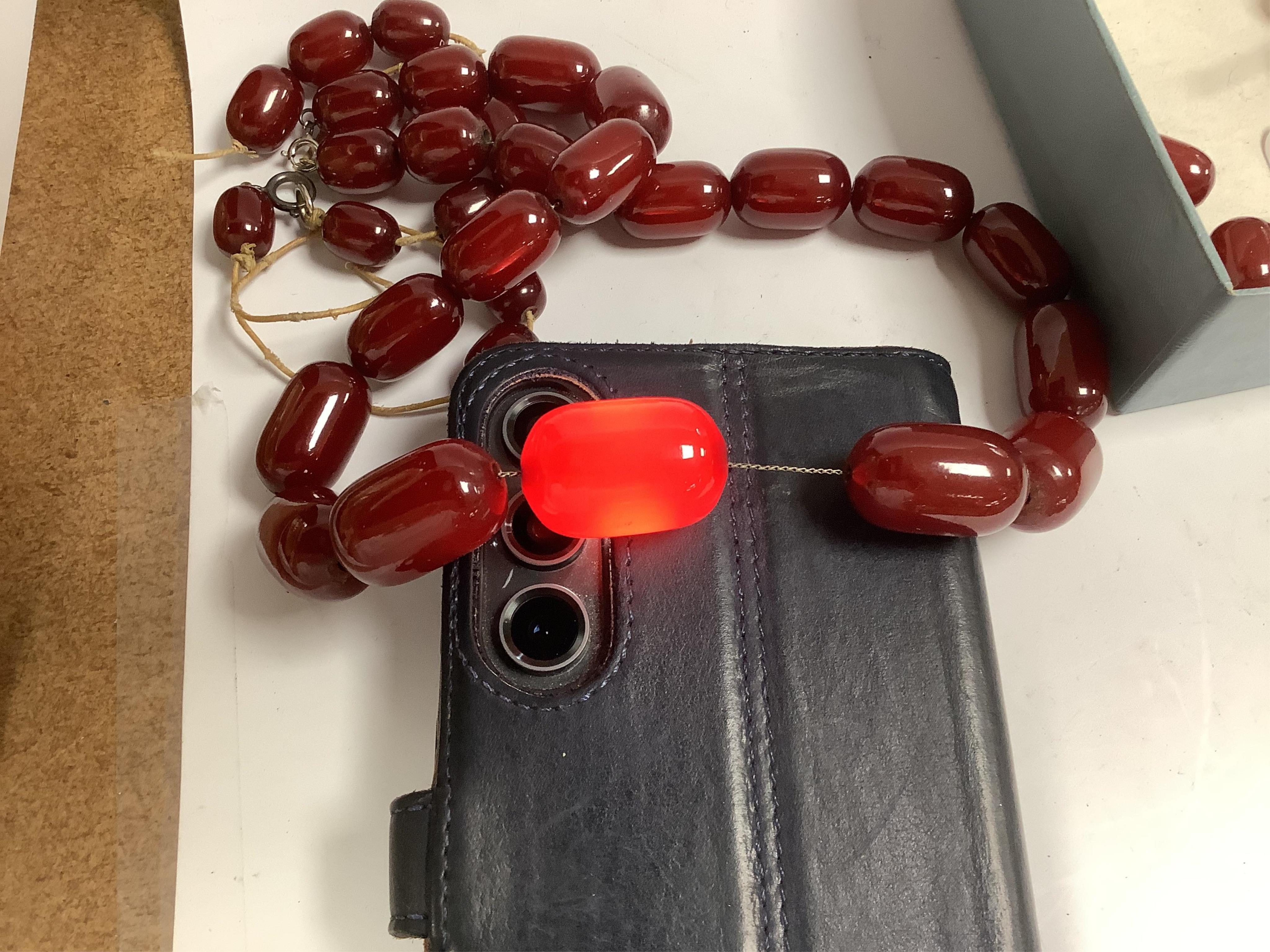 A simulated cherry amber bead necklace, (needs re-stringing), gross weight 136 grams. Condition - poor